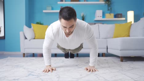 Young-athlete-man-doing-push-ups-in-living-room-at-home.